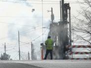 Construction worker standing next to equipment for South 10th Street storm drain reroute project