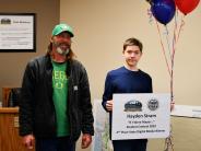 Hayden Stram with Mayor Rick Scholl holding balloons and sign announcing state winning