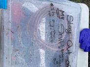Clear plastic storage container with black handwriting 