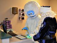 Abominable Snowman being fingerprinted by Officer Claus
