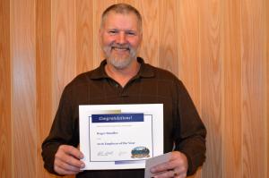 Building Maintenance Utility Worker Roger Stauffer stands with his employee of the year certificate. 