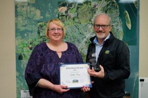 Kathy Payne on left with City Administrator John Walsh on right holding certificate and clear award in the shape of a star.