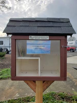 St. Helens Little Free Library with a coming soon sign on front of box 