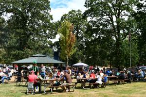 People eating at picnic tables in McCormick Park at previous Citizens Day in the Park. 