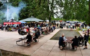 People eating at picnic tables in park during Citizens Day 2019 