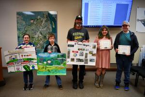 Mayor with student winners and participants holding entries and certificates