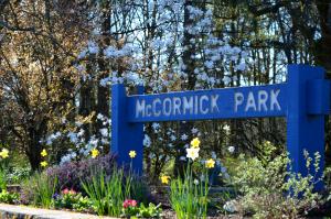 Blue McCormick Park entrance sign with landscaping and flowers surrounding sign. 