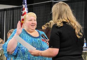 Kathy Payne with right hand raised, taking oath of office with fellow recorder administering oath