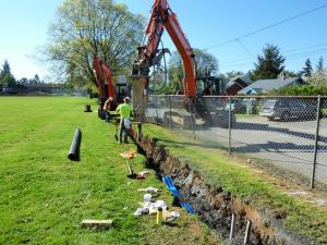 Contractors in ditch with construction equipment 