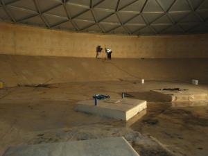 Two workers testing inside lining of water reservoir 