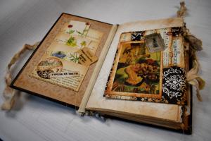 An open journal that uses repurposed paper and materials as decorative art on the pages