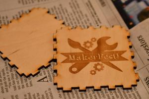 Wooden sides of a small box ready to be put together with MakerFest logo on top 