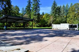 Expanded Veterans Memorial Plaza with covered seating area, memorial wall, and paved plaza. 