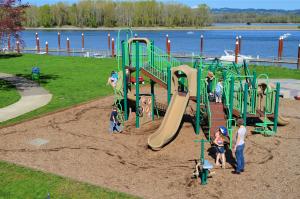 A summer view of Columbia View Park playground from above with several children playing on the equipment