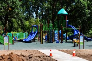 Newly installed McCormick Park playground equipment with graded dirt in forefront. 