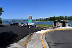 Entrance to Grey Cliffs Waterfront Park with restroom facilities and parking lot visible and Columbia River in background 