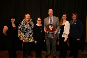 Police Chief Terry Moss holding the Max Patterson award with police and city staff 