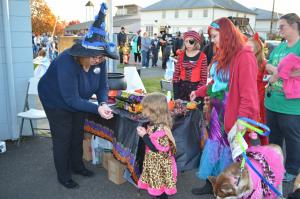 St. Helens police staff member passes out candy to dressed up trick-or-treaters