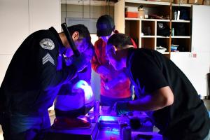 St. Helens officer shows reserve academy students crime scene techniques using fluorescent light. 