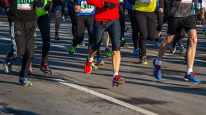 Group of runners from the waist down running in a race on a road