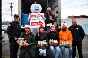 Police and officers gathered at back of food truck with donations for Donut Day