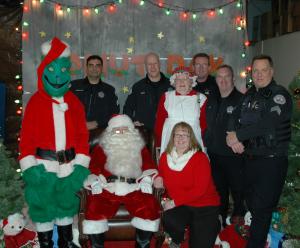 Photo of St. Helens Police Department staff with Santa Claus, Ms. Claus and The Grinch