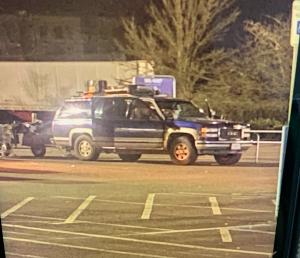 Security footage still of suspect vehicle in Walmart parking lot, Blue Chevy Suburban 