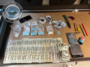 Items seized in search warrant execution including cash and drugs 