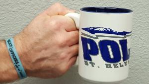 Photo of a hand holding a St. Helens Police Department coffee mug.