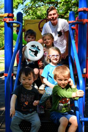 St. Helens Recreation Program Assistant with toddlers on playground equipment at Recreation Program activity. 