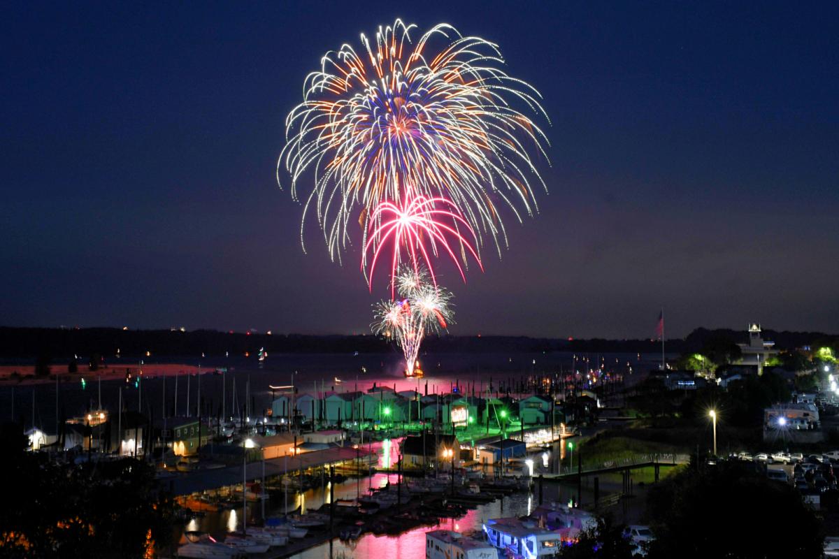 Fireworks over Columbia River on St. Helens riverfront with buildings in foreground